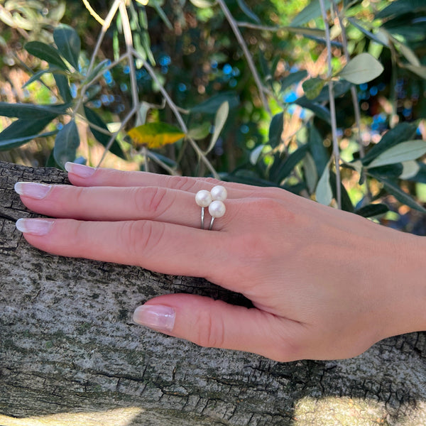 Vue de la bague trèfle portée sur main de mannequin avec ces 3 perles d'eau douce blanche de 6.5 mm formant un trèfle sur un anneau d'argent de taille ajustable