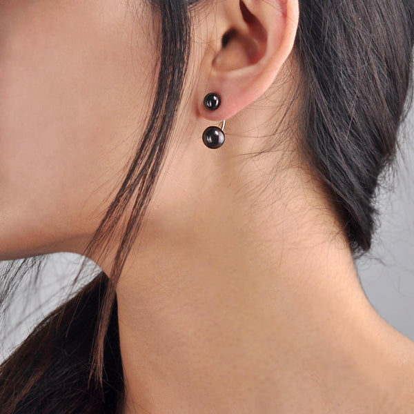 Vue des Boucles d’oreilles en forme de C portées avec perles de culture d’eau douce noires et monture en argent 925.