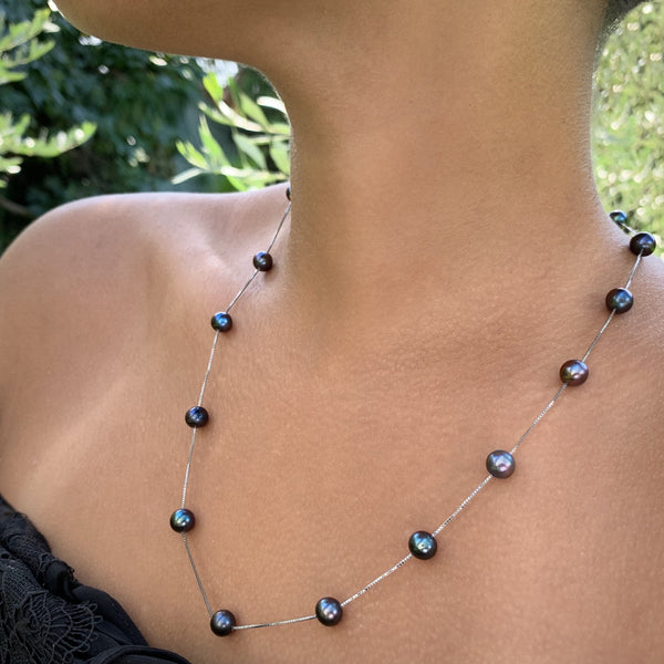 Collier Charmeuse en chaîne serpentine argent 925 orné de perles de culture d’eau douce noires porté en version longue.