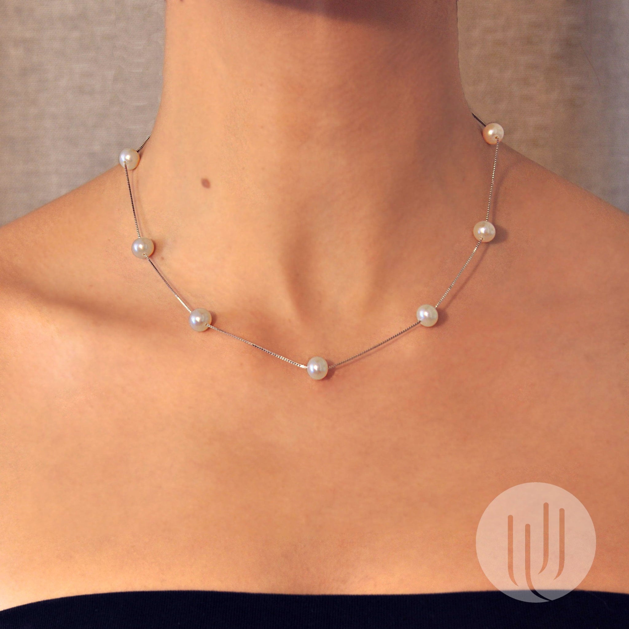 Vue portée sur mannequin d’un collier composé de 9 perles noires taille 7mm semi rondes alignées sur une chaîne en argent 925, d’une longueur de 45 cm  taille 45 cm .