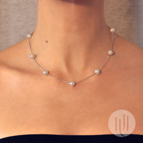 Vue portée sur mannequin d’un collier composé de 9 perles noires taille 7mm semi rondes alignées sur une chaîne en argent 925, d’une longueur de 45 cm  taille 45 cm .